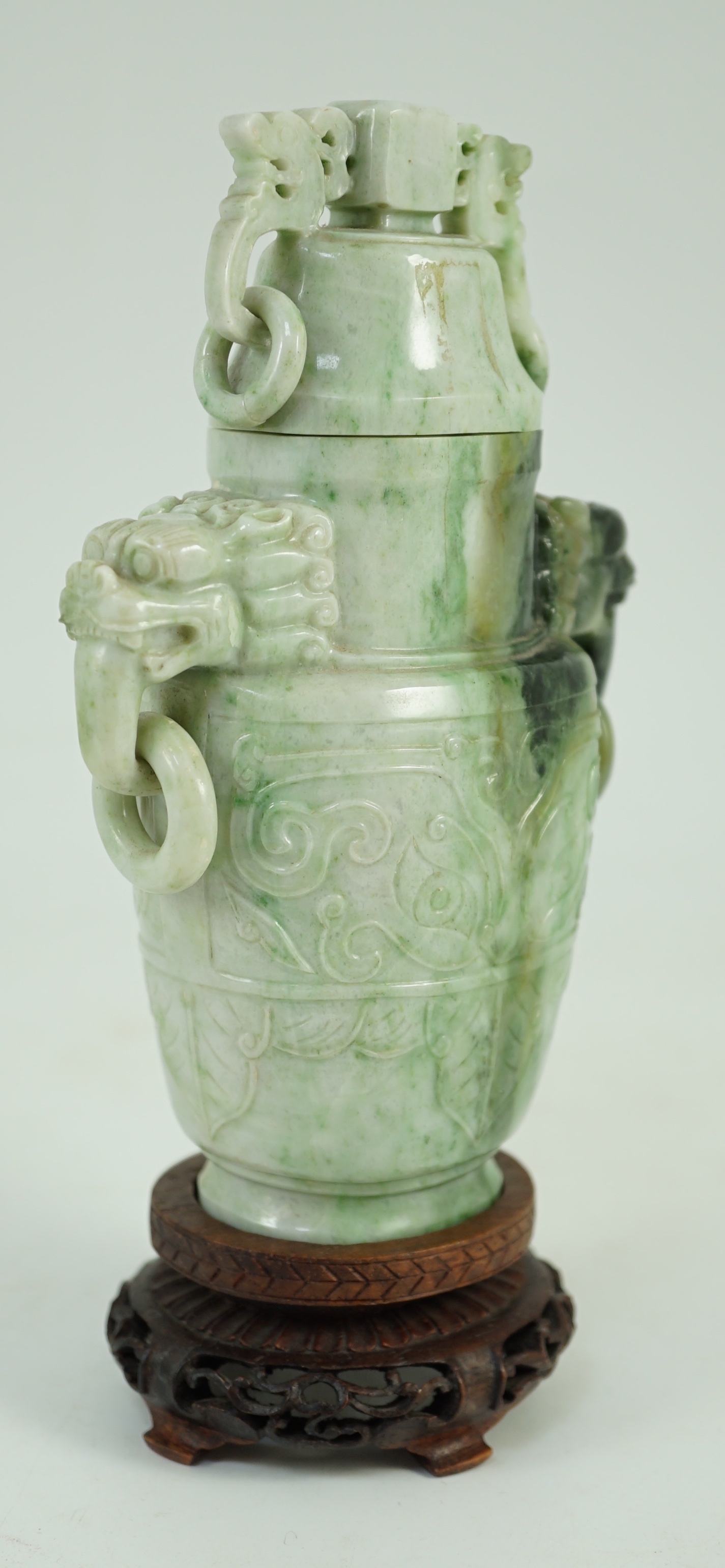 A Chinese archaistic jadeite two-handled vase and cover, first half 20th century, 16 cm high, excluding wood stand